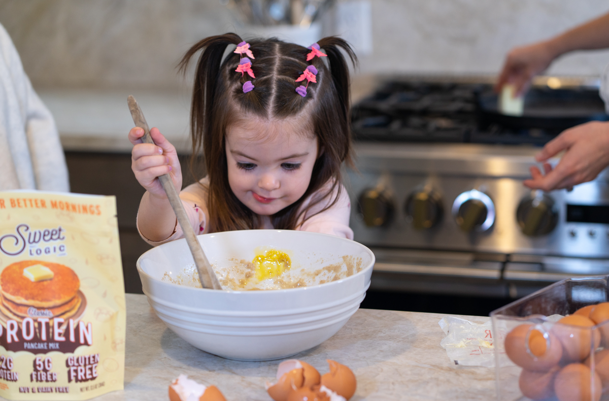A girl stirring Sweet Logic Classic Protein pancake batter